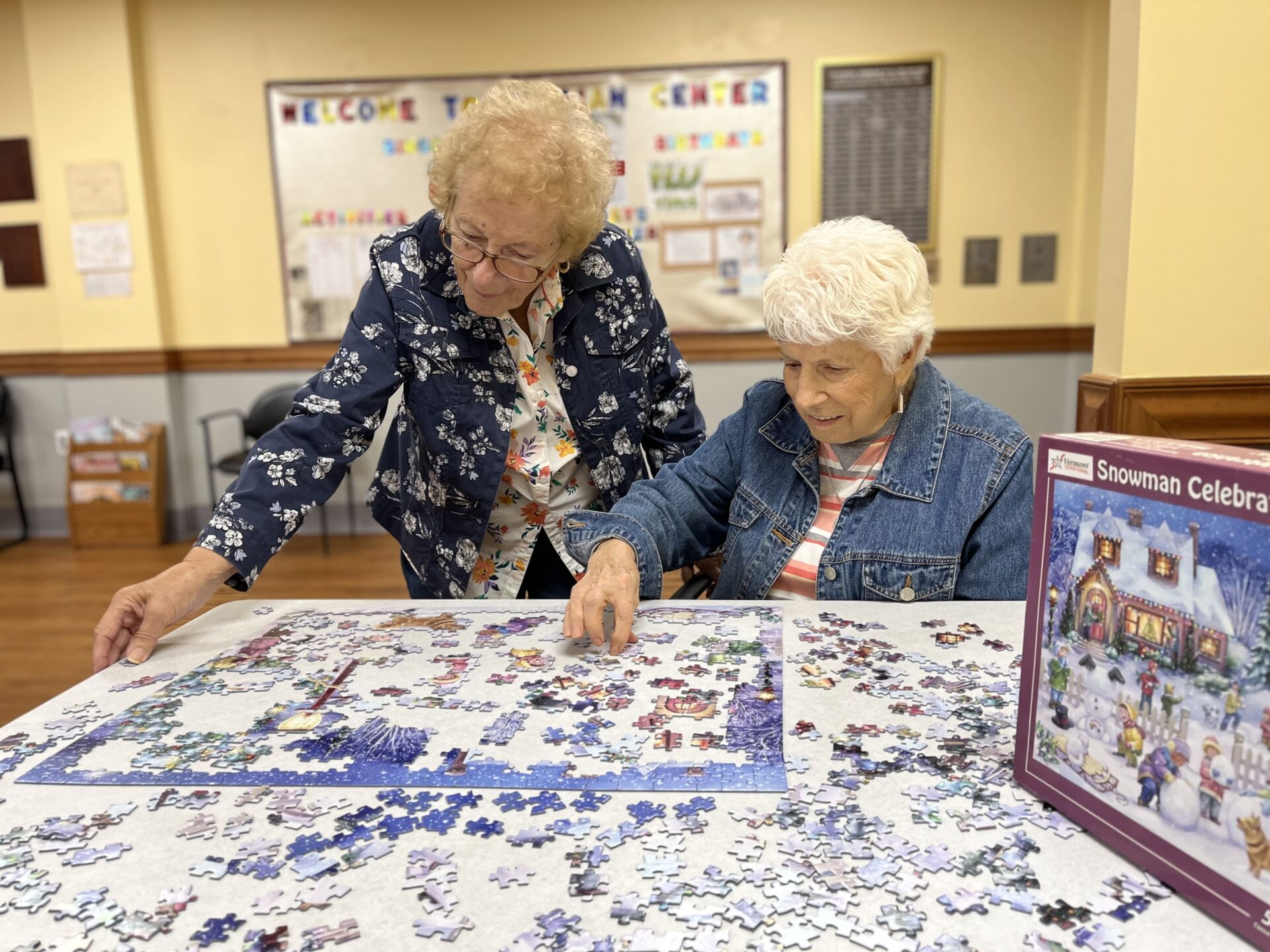 two woman solving a puzzle